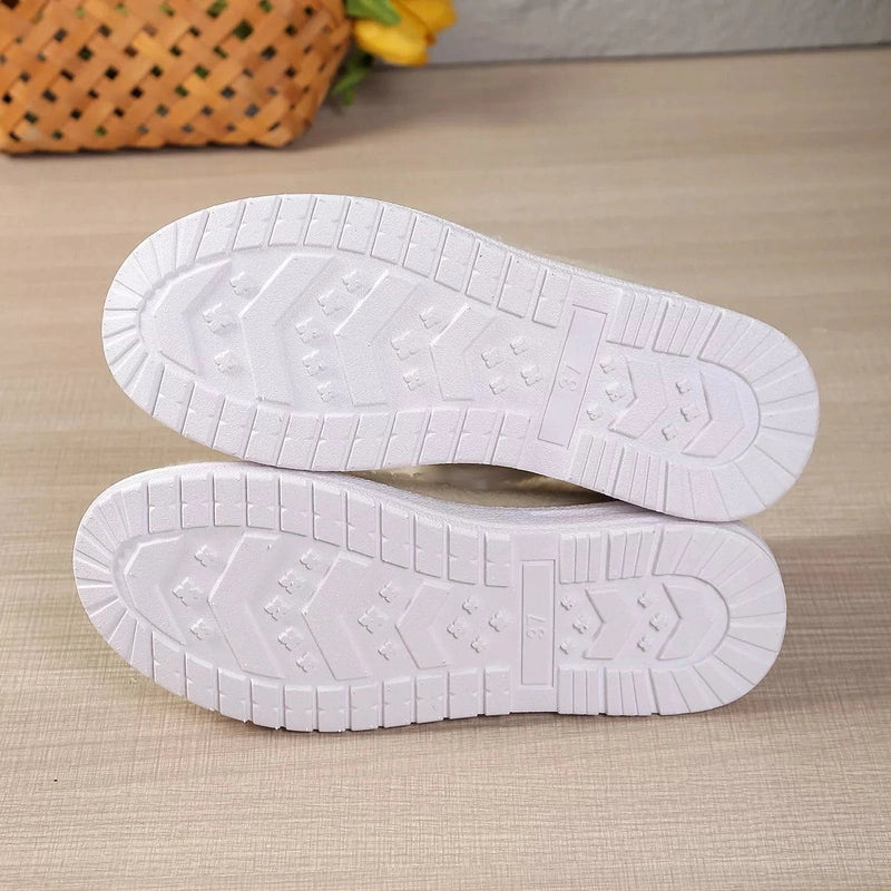 Bottom view of white rubber soles with chevron traction pattern