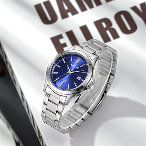 Side angle view of silver stainless steel watch with blue dial on magazine page