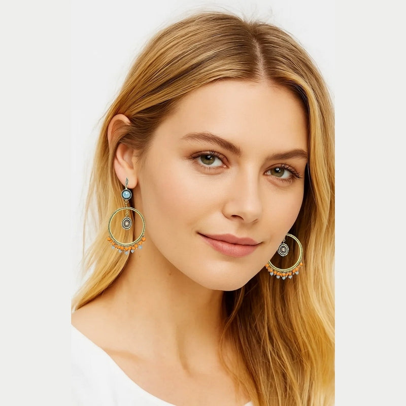 Vintage boho dangle hoop earrings with gold-tone metal, blue cabochon studs, and orange beads