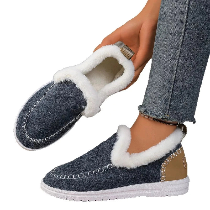 Hand holding dark blue slip-on to show lining and tan heel accent