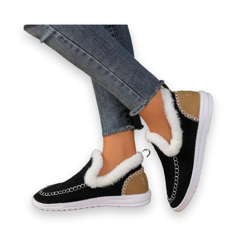 Side view of black slip-ons with tan heel panel and white sole