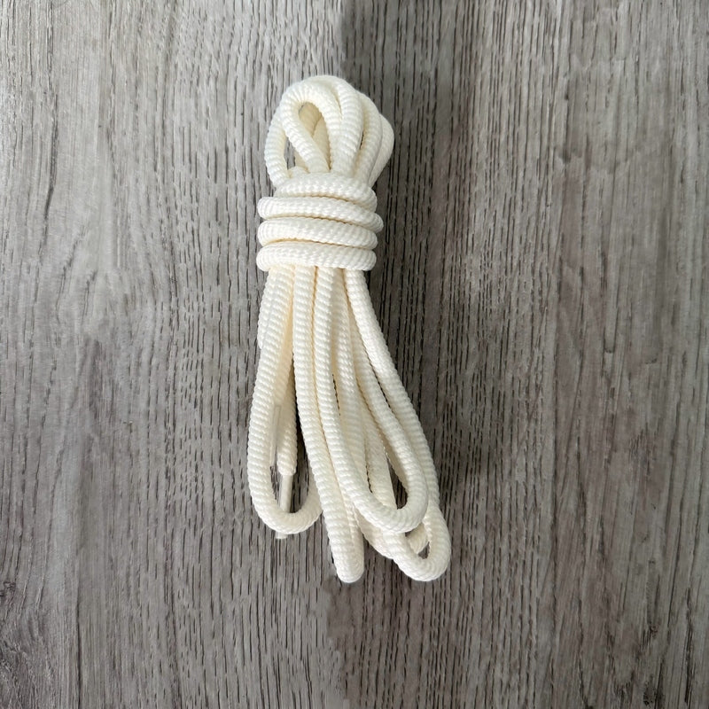 White round ribbed shoelaces with spiral texture on wood