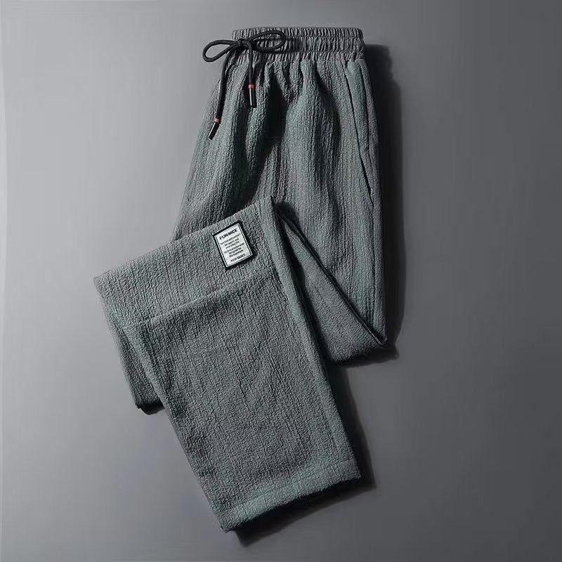 Green men's plus-size loose-fit cropped pants with crinkled material and fashion label detail