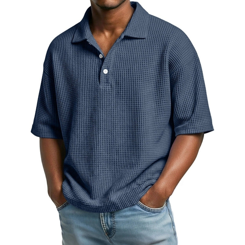 Navy blue men's waffle knit polo shirt featuring short sleeves and button details