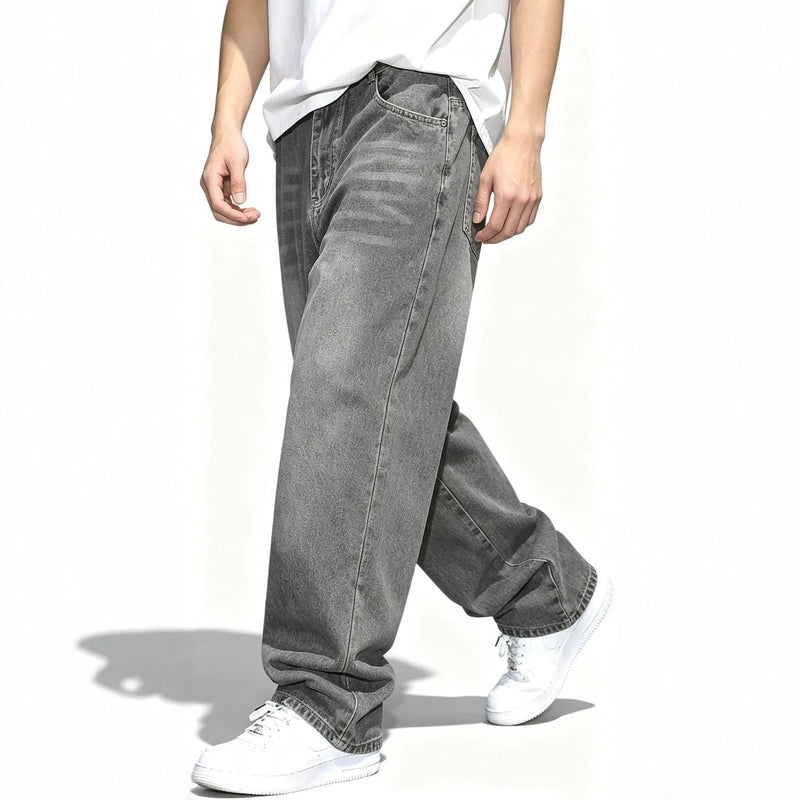 Side view of men's baggy gray washed jeans showing relaxed drape and distressed pattern