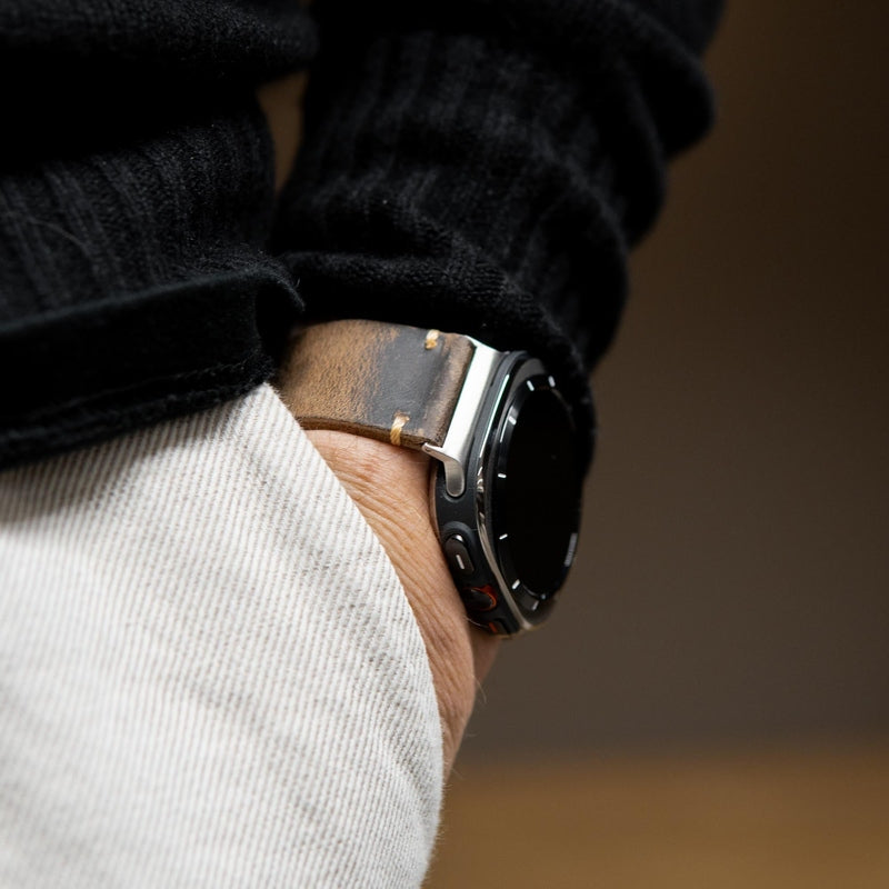 Distressed brown leather watch band with silver hardware on wrist