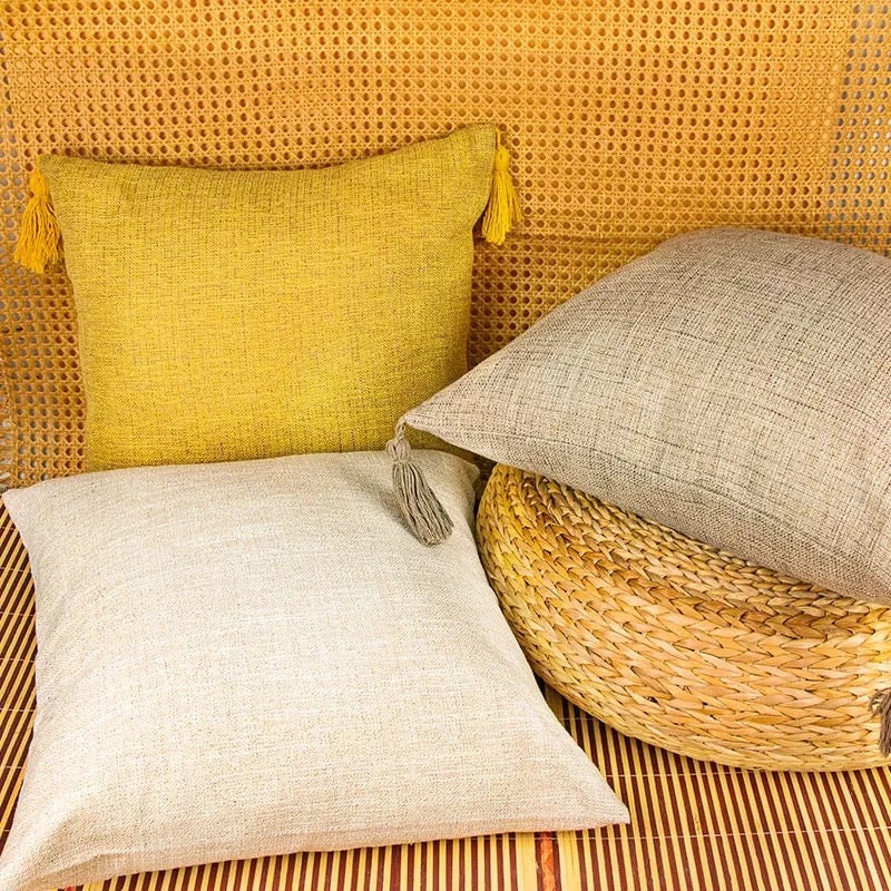 Mustard, oatmeal, and taupe throw pillow cases with tassels on rattan background