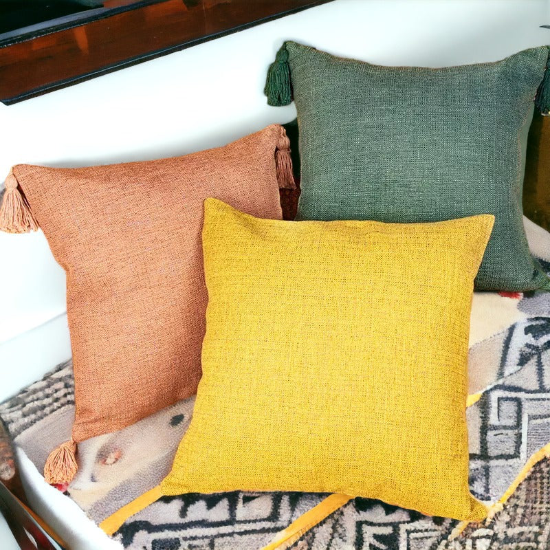 Rust, mustard, and forest green textured cotton linen throw pillows with tassels