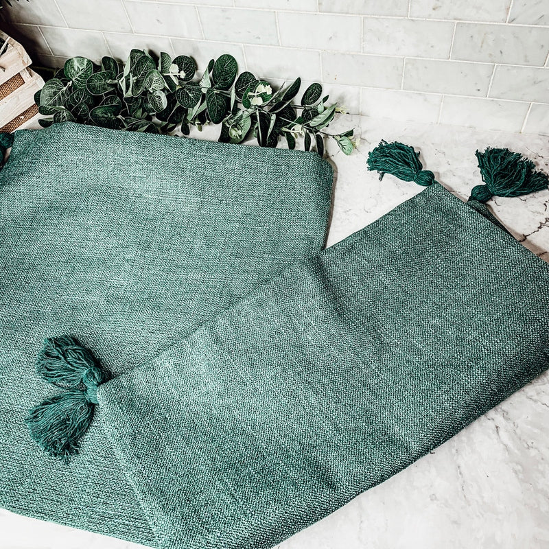 Emerald green textured cotton linen pillow case with tassel detail flat lay