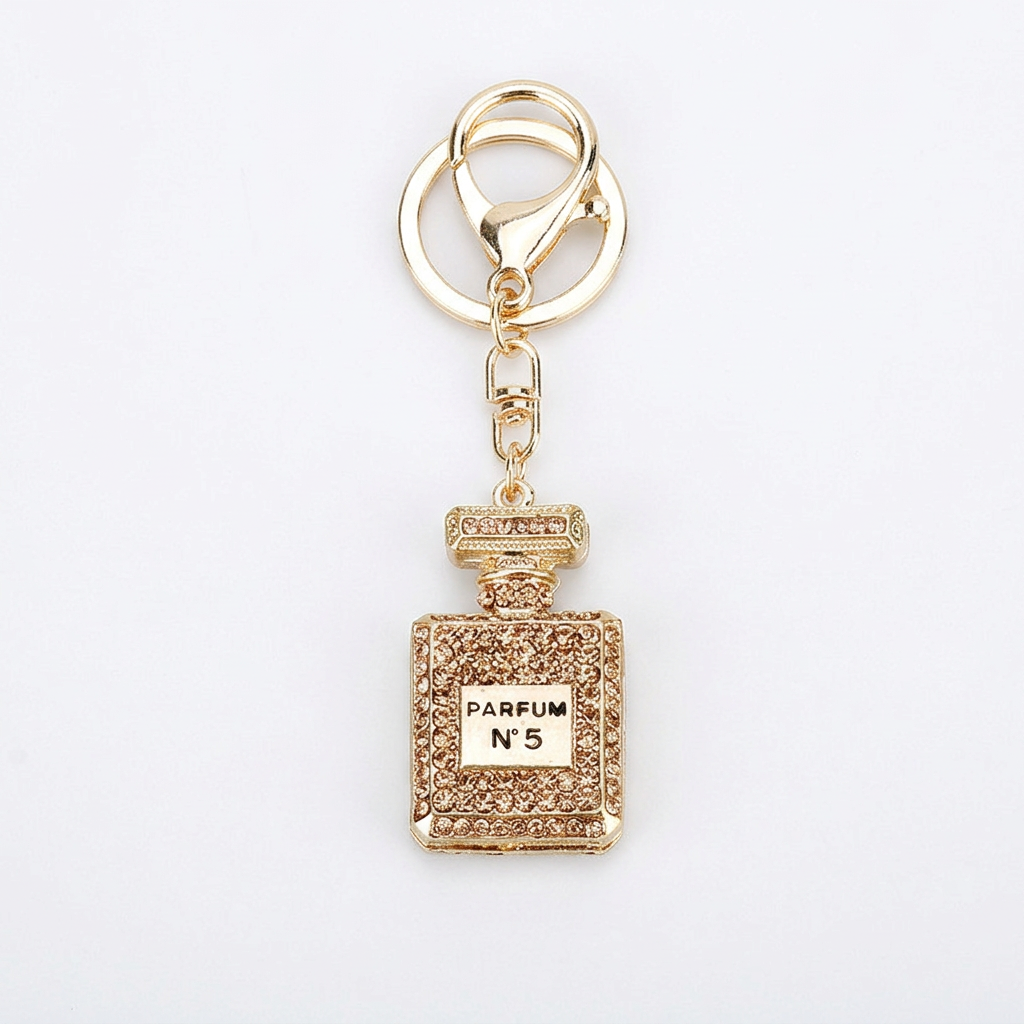 Champagne-tone perfume keychain on white