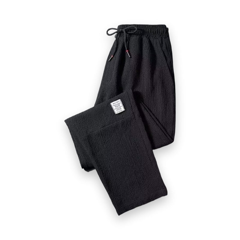 Black men's loose-fit cropped straight-leg pants with crinkled texture and drawstring waist