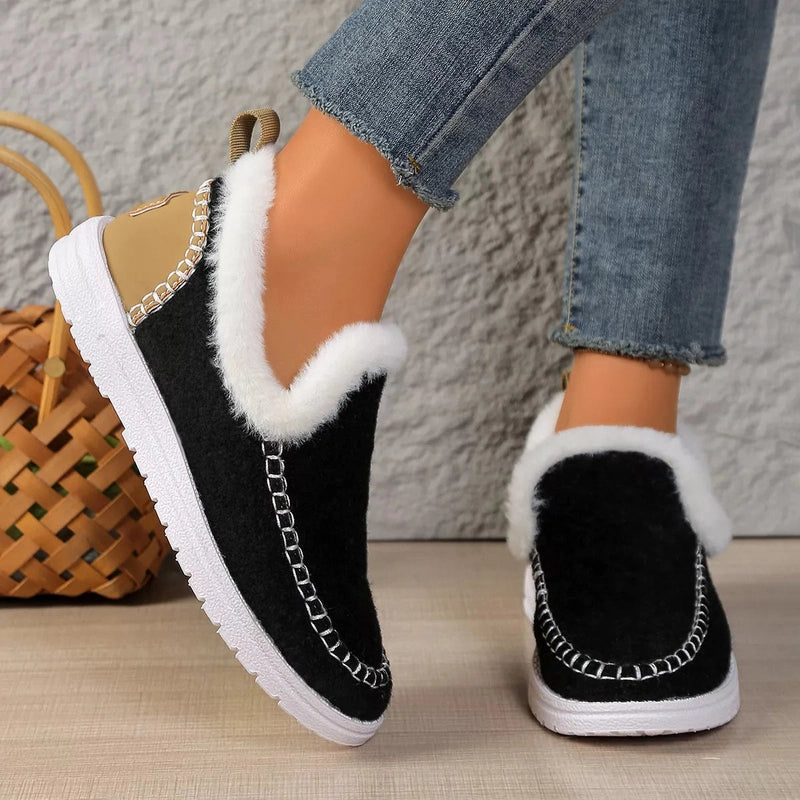 Close-up rear angle of black slip-ons with gold loop heel